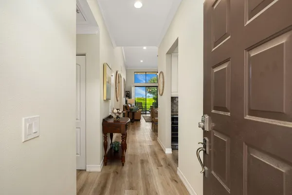 a view of a hallway view with wooden floor and a living room