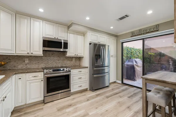 a kitchen with stainless steel appliances granite countertop a refrigerator microwave and stove top oven