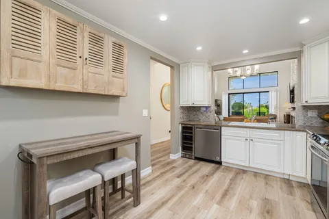 a kitchen with granite countertop a stove a sink and a refrigerator