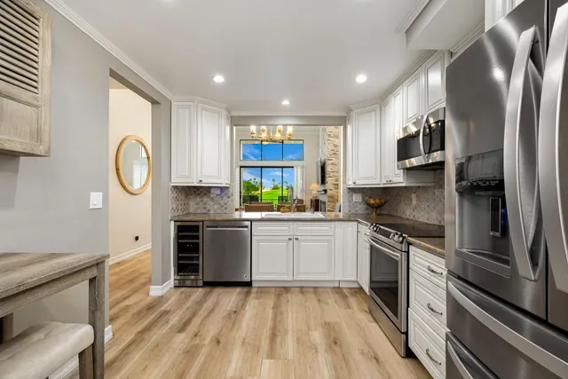 a kitchen with stainless steel appliances granite countertop a stove a sink and a refrigerator