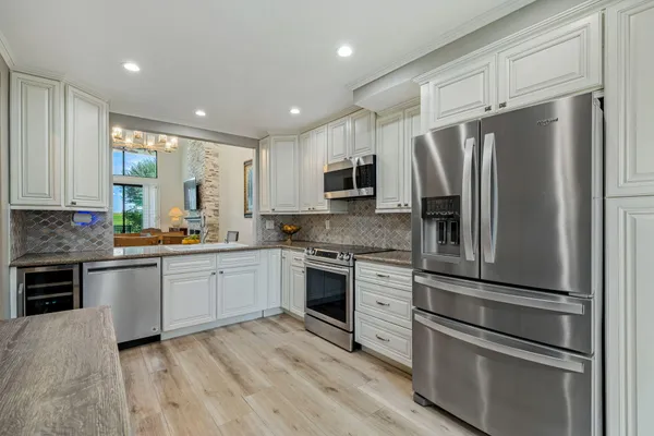 a kitchen with granite countertop stainless steel appliances and wooden cabinets