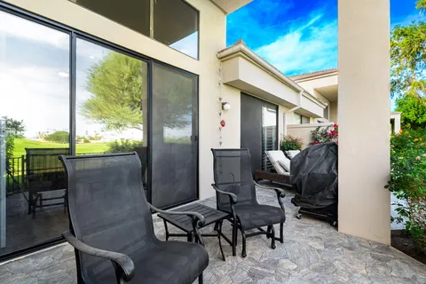 a balcony with chairs and a potted plant