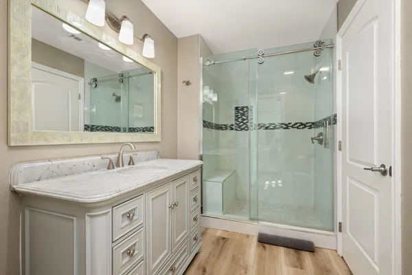 a bathroom with a granite countertop sink and a mirror