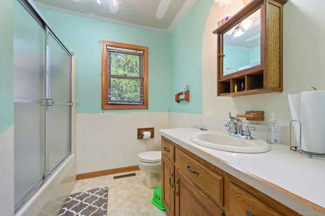 a bathroom with a sink a toilet and shower