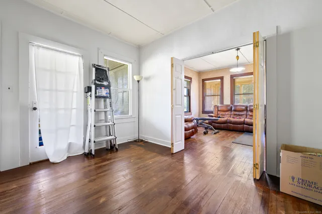a view of a livingroom with wooden floor and furniture