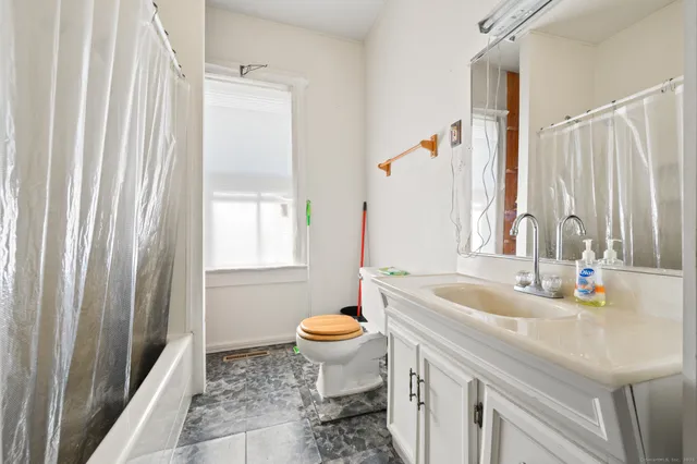a bathroom with a sink toilet and a mirror