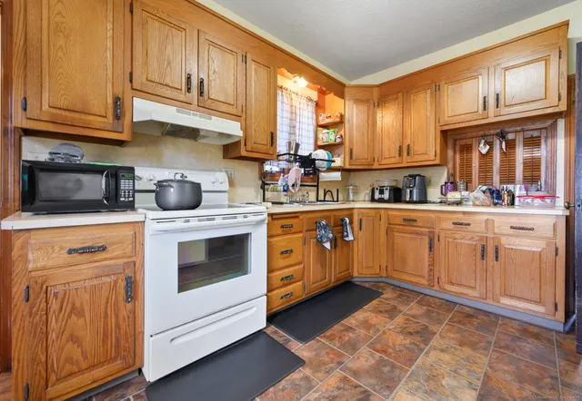 a kitchen with a stove sink and cabinets