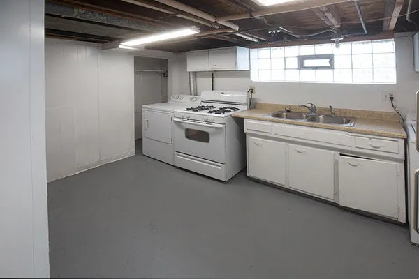 a kitchen with granite countertop a sink cabinets stainless steel appliances and a window