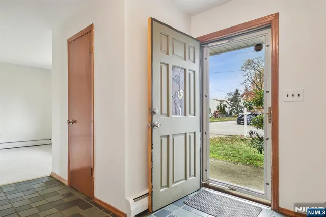a view of an empty room with glass door and wooden floor