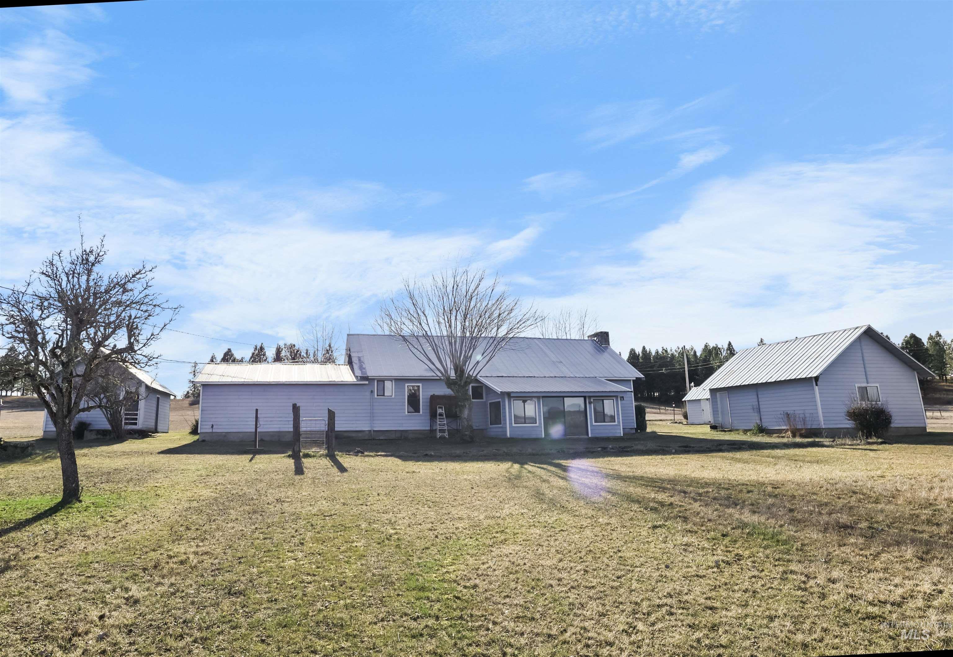 216 Ulmer Road Kooskia, ID 83539 - Photo 16 of 49 Rear view of house with a lawn, a metal roof, and a chimney