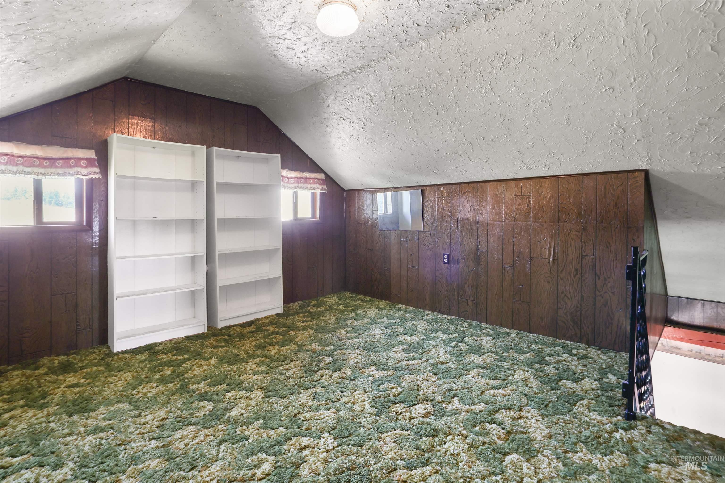 216 Ulmer Road Kooskia, ID 83539 - Photo 21 of 48 Additional living space with carpet floors, wooden walls, and a textured ceiling