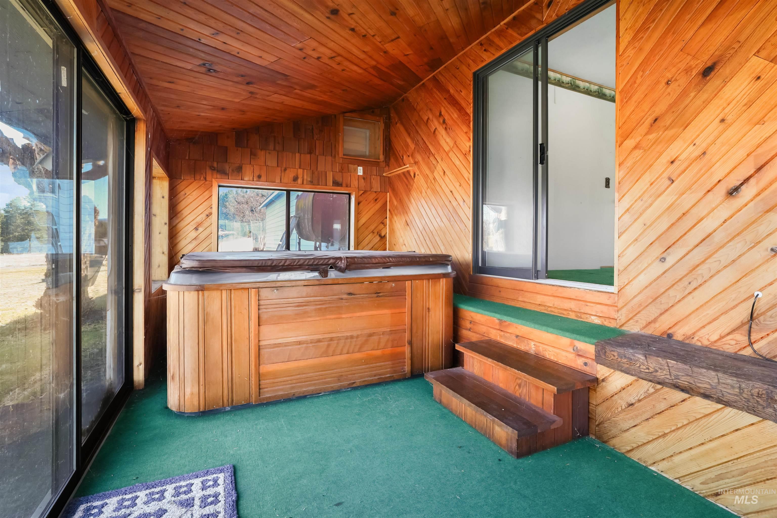 216 Ulmer Road Kooskia, ID 83539 - Photo 24 of 48 Misc room with a jacuzzi, carpet, a vaulted wooden ceiling, and wooden walls