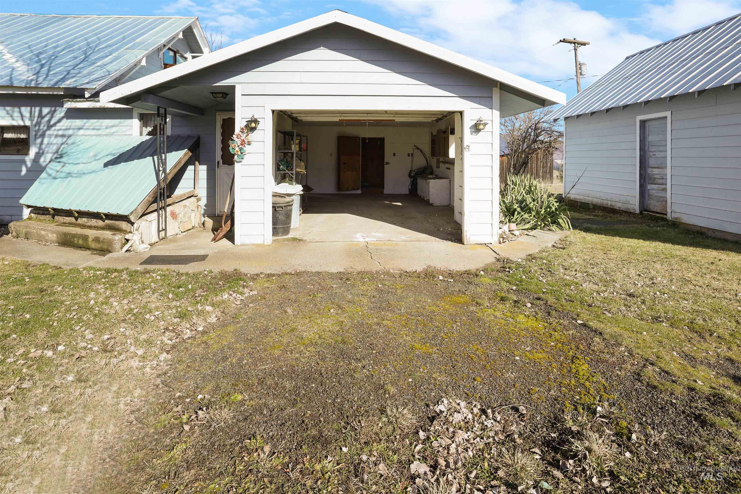 216 Ulmer Road Kooskia, ID 83539 - Photo 28 of 49 Rear view of house featuring a garage and a yard