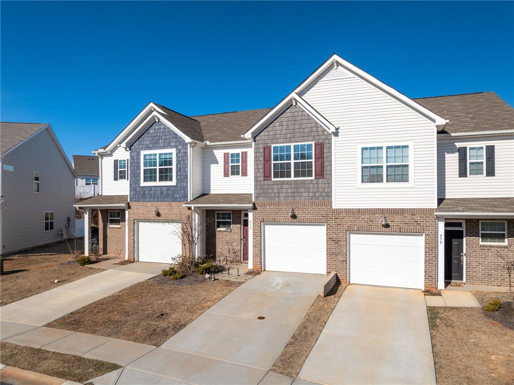 452 Bee Cv Way Pendleton, SC 29670 - Photo 2 of 37 This townhome features a charming brick and siding facade with attached garages.
