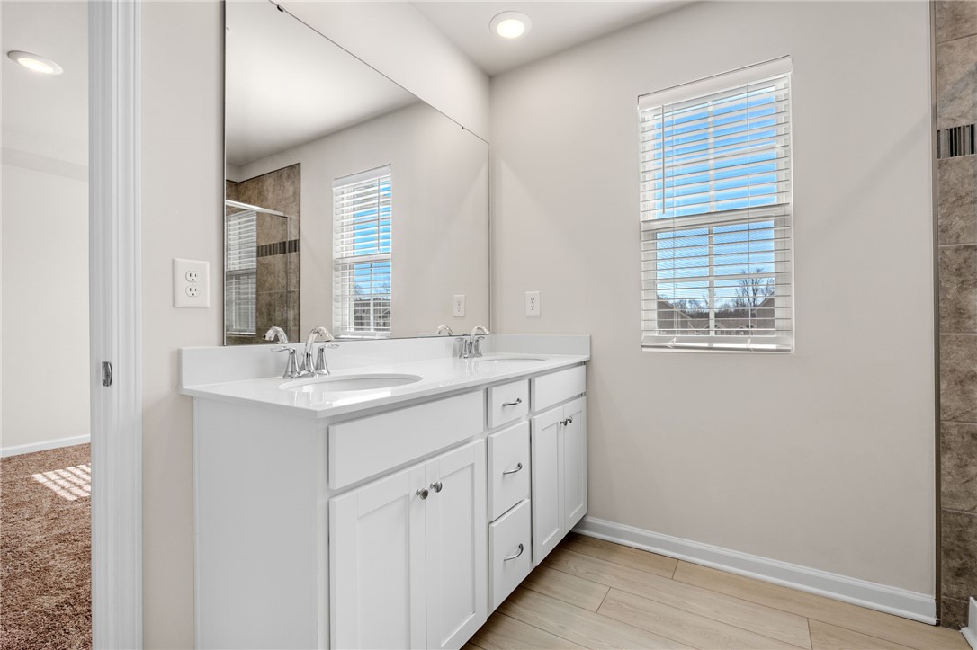 452 Bee Cv Way Pendleton, SC 29670 - Photo 23 of 37 This spacious bathroom features dual vanities and modern tile flooring.