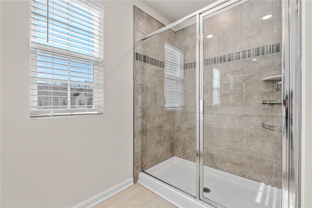 452 Bee Cv Way Pendleton, SC 29670 - Photo 24 of 37 This bright bathroom features a spacious shower with tile surround and a convenient window.