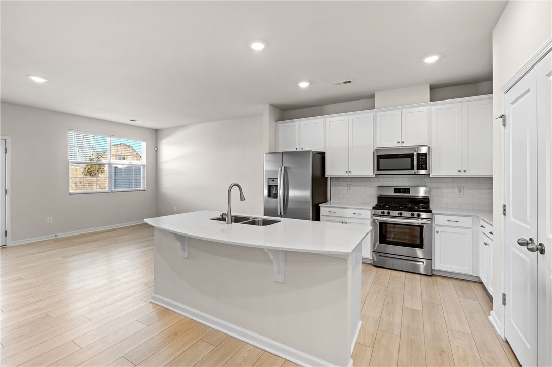452 Bee Cv Way Pendleton, SC 29670 - Photo 8 of 37 This modern kitchen features a spacious island and seamlessly connects to the living area.