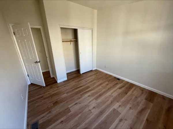 an empty room with wooden floor and entrance