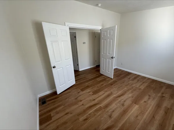 an empty room with wooden floor and stairs
