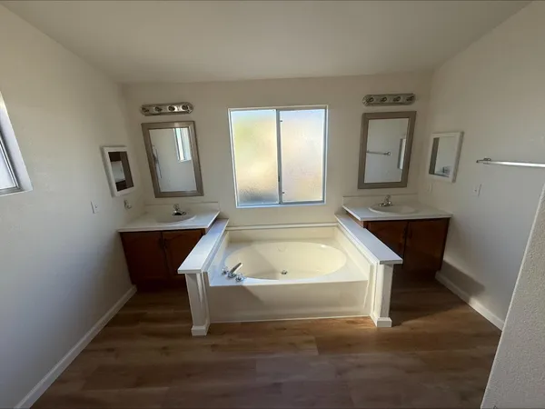 a spacious bathroom with a bathtub shower sink and mirror