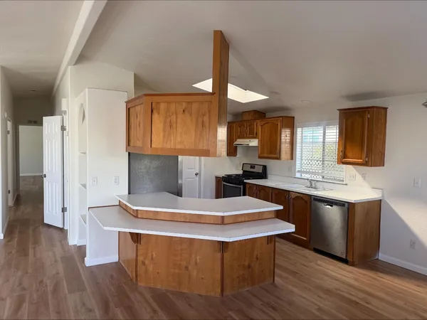 a kitchen with stainless steel appliances kitchen island granite countertop a stove a sink and a refrigerator