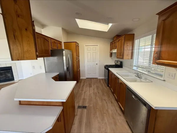 a kitchen with a sink a refrigerator and trees