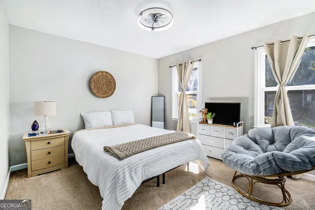 a bedroom with a bed a couch and a window