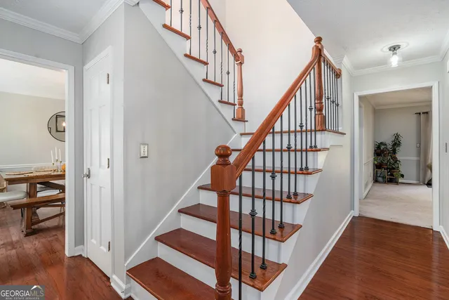 a view of staircase with wooden floor and a rug
