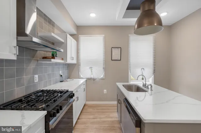 a kitchen with granite countertop a sink stove and cabinets
