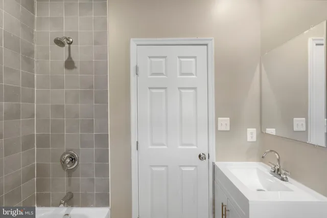 a bathroom with a sink a glass door shower and a mirror