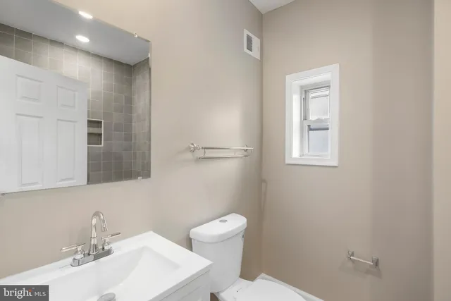 a bathroom with a sink a toilet and a mirror