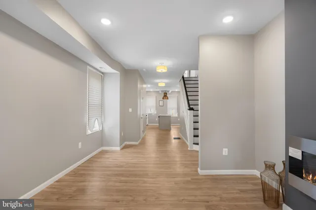 a view of an empty room with wooden floor and windows