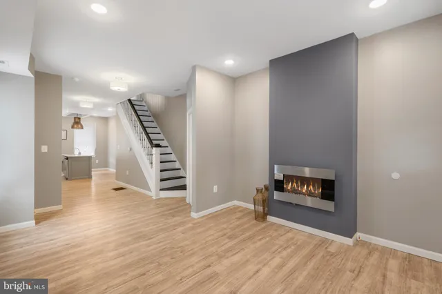 a view of a livingroom with wooden floor and stairs