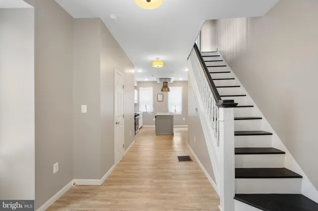 a view of a hallway with wooden floor and staircase