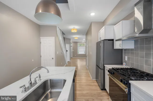 a kitchen with kitchen island granite countertop a sink stove and refrigerator