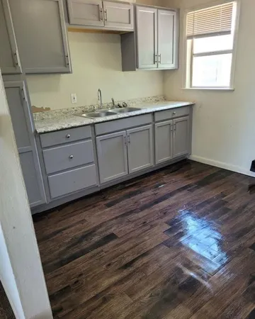 a kitchen with granite countertop wooden cabinets a sink and dishwasher