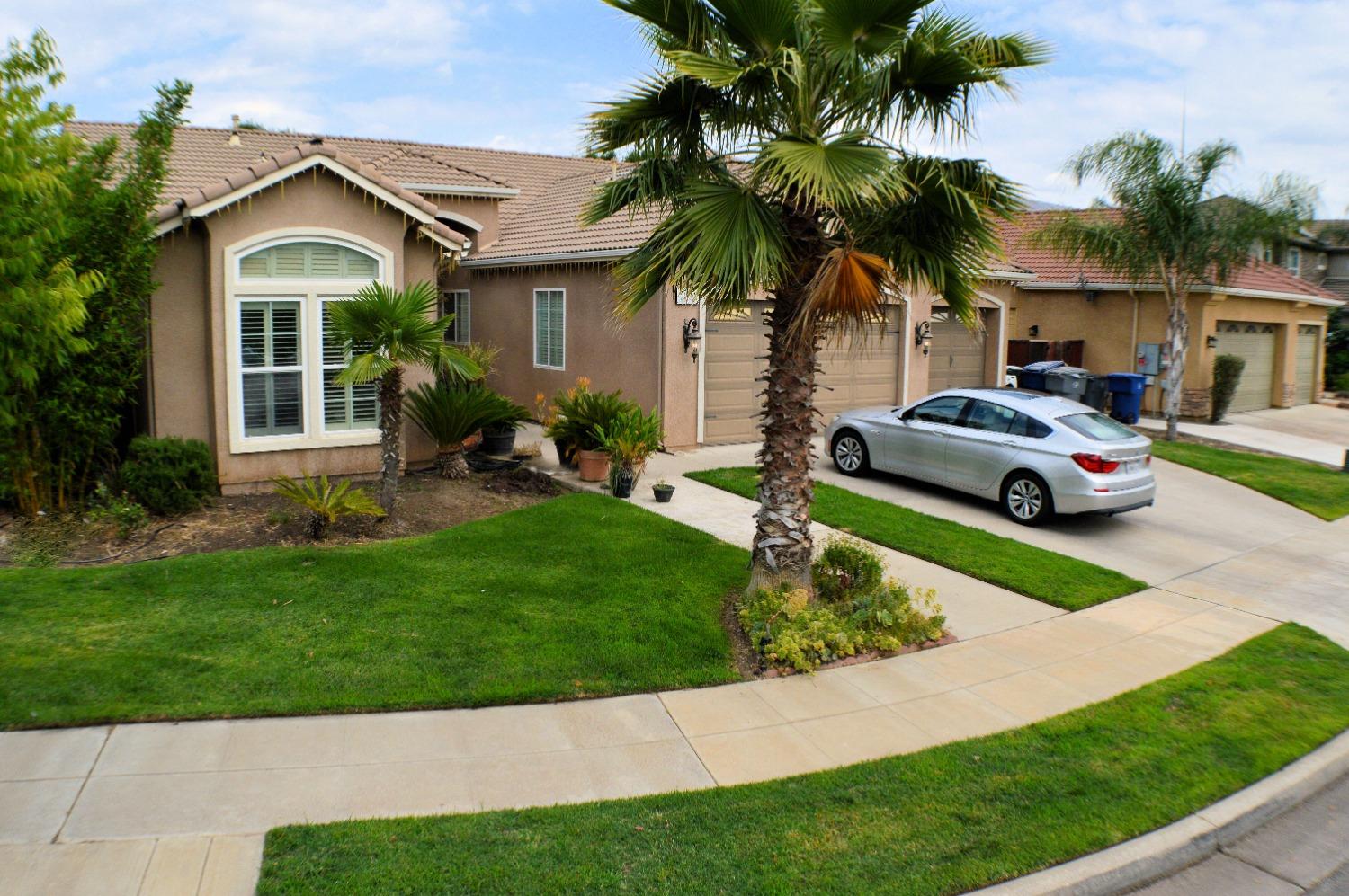 a front view of a house with a garden and plants