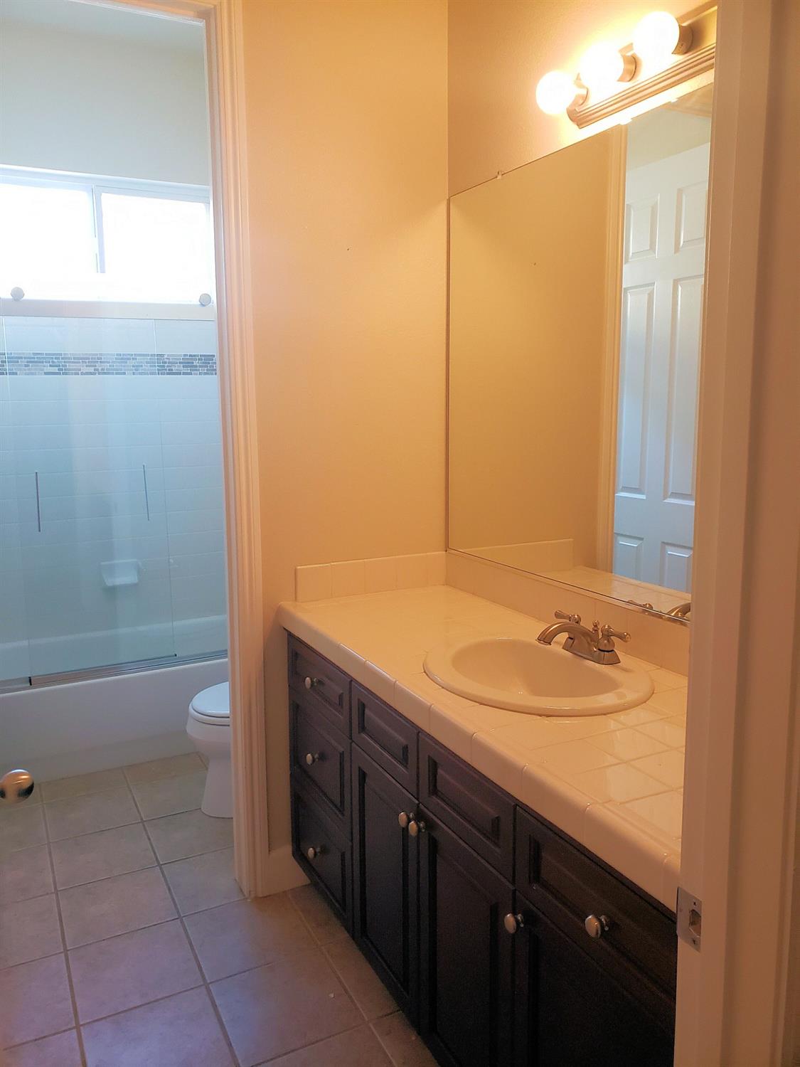 2529 Maine Avenue Clovis, CA 93619 - Photo 6 of 11 a bathroom with a granite countertop sink toilet and shower