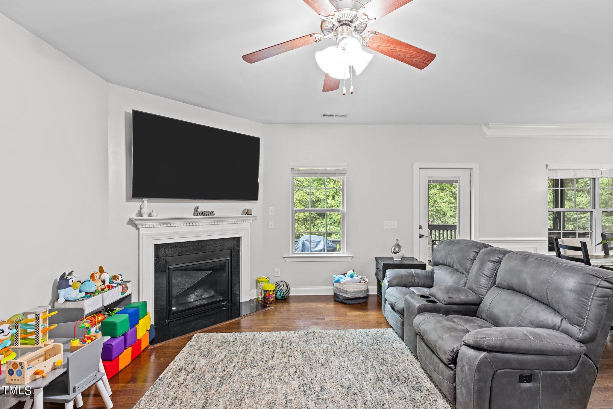 417 Bryerstone Drive Willow Spring, NC 27592 - Photo 12 of 43 a living room with furniture a flat screen tv and a fireplace