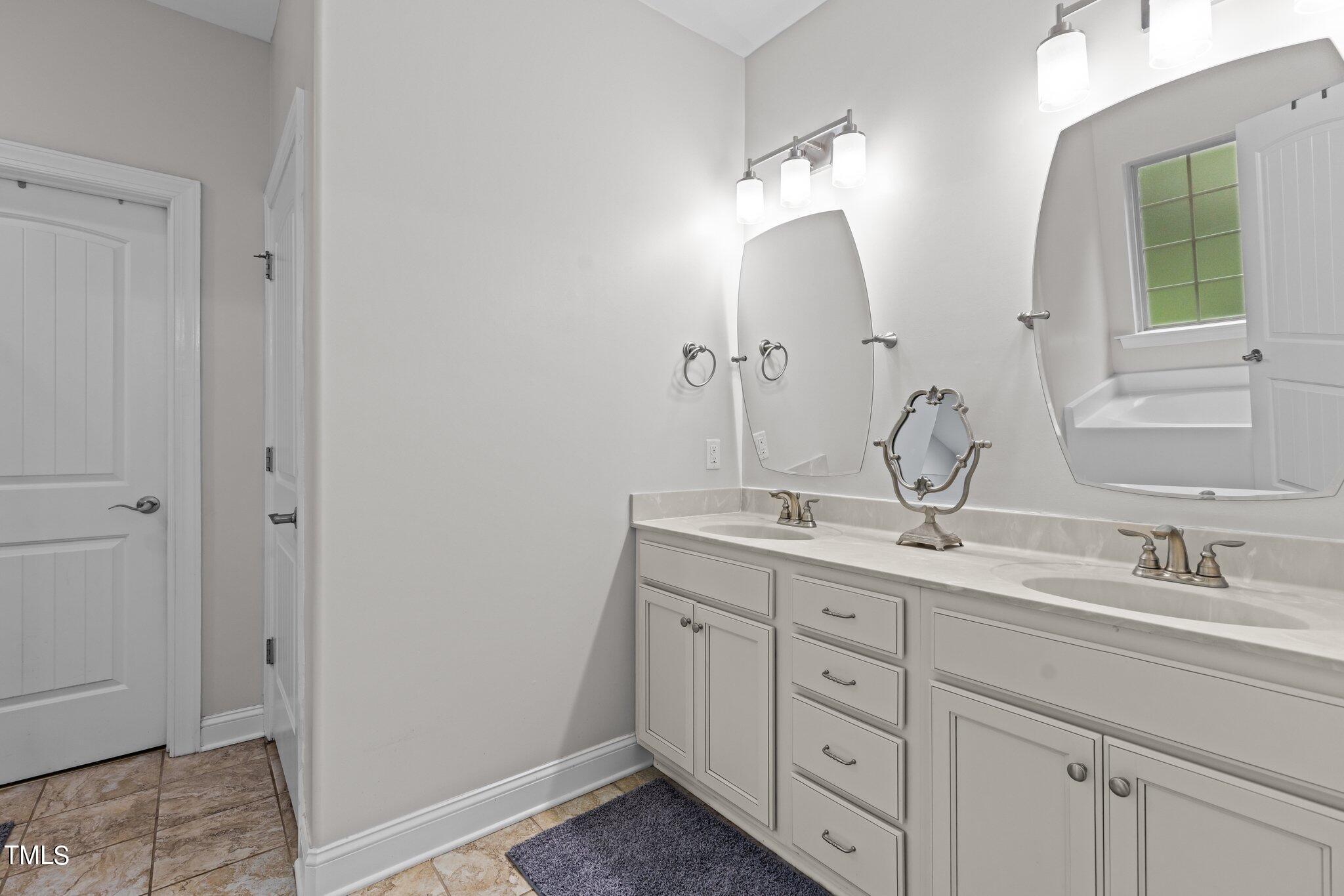 417 Bryerstone Drive Willow Spring, NC 27592 - Photo 20 of 43 a bathroom with double sink and a mirror