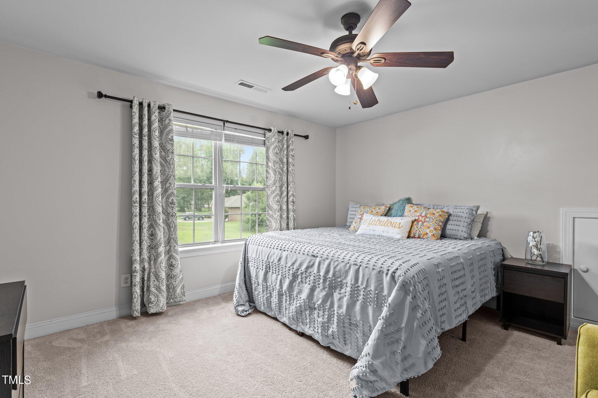 417 Bryerstone Drive Willow Spring, NC 27592 - Photo 29 of 43 a bedroom with a large bed and a chandelier fan