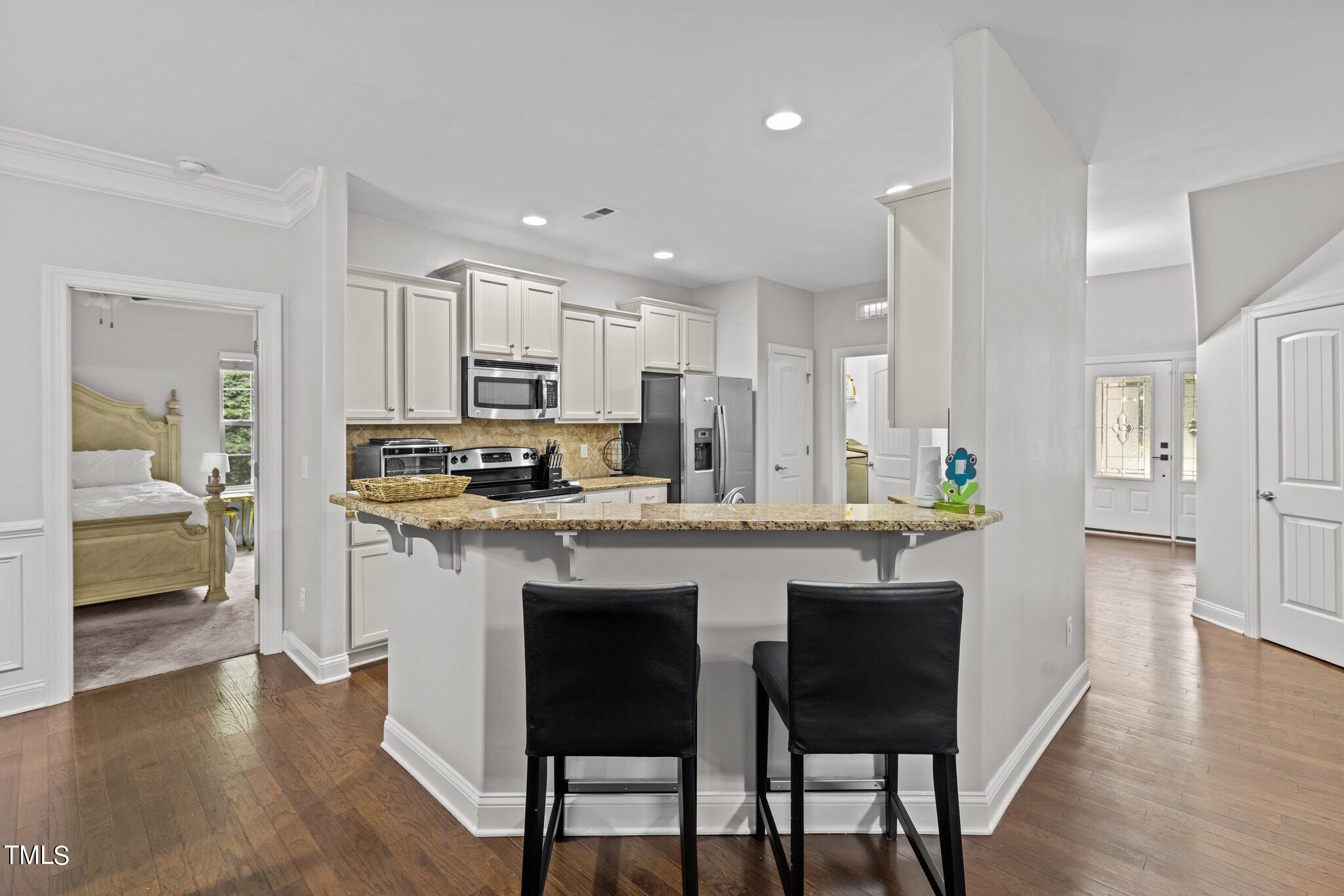 417 Bryerstone Drive Willow Spring, NC 27592 - Photo 3 of 43 a kitchen with stainless steel appliances granite countertop a table chairs refrigerator and sink