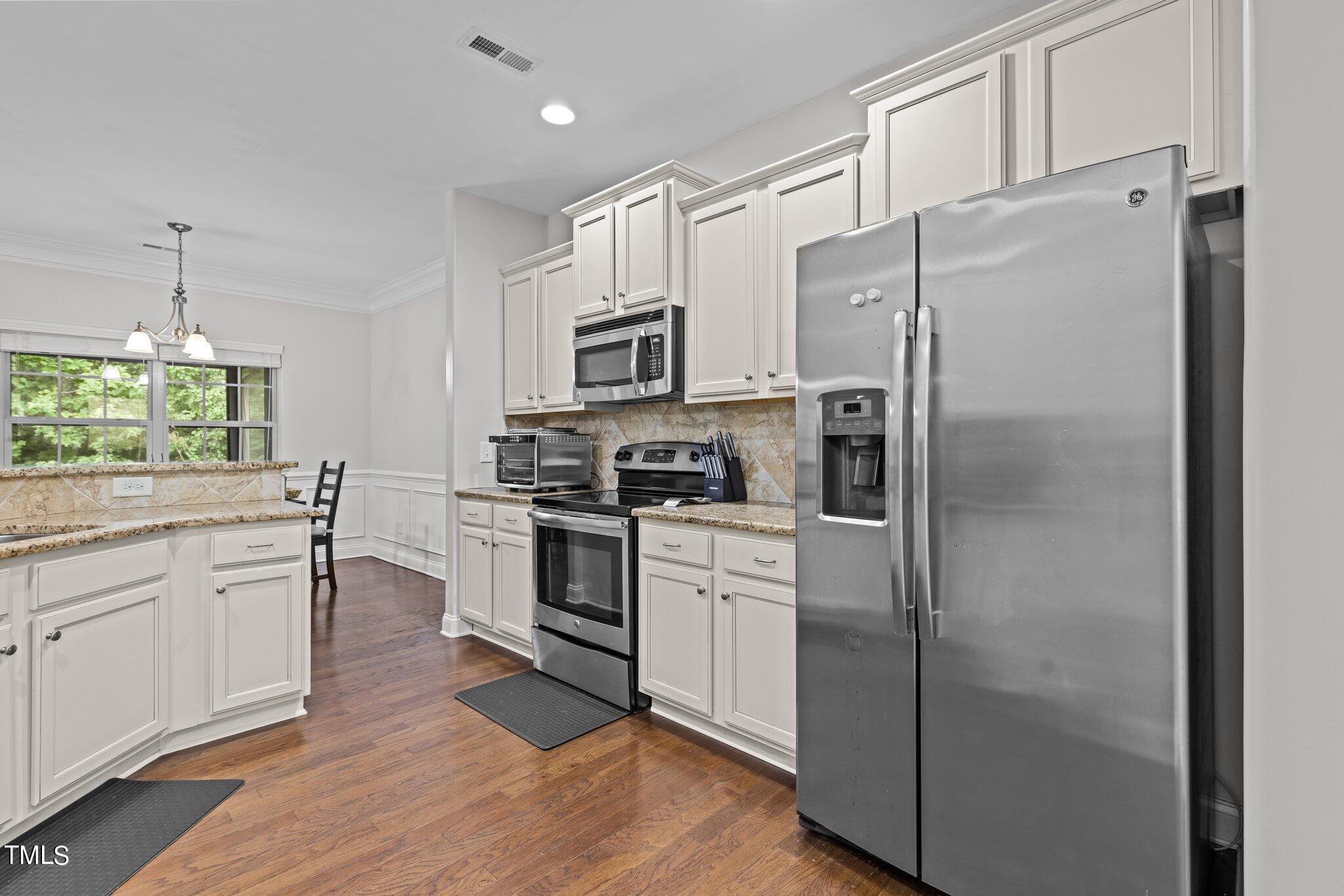 417 Bryerstone Drive Willow Spring, NC 27592 - Photo 4 of 43 a kitchen with a refrigerator cabinets and wooden floor