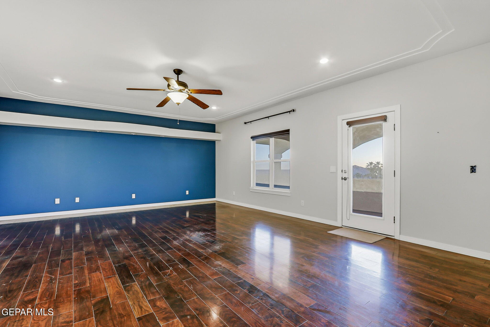 1297 Cypress Ridge Drive El Paso, TX 79912 - Photo 54 of 77 a view of an empty room with wooden floor and a ceiling fan