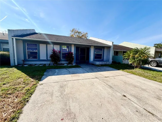 a front view of a house with a yard and potted plants