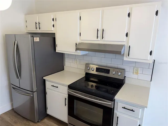 a kitchen with stainless steel appliances and white cabinets