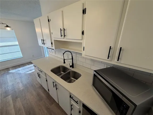 a kitchen with stainless steel appliances a sink a stove and cabinets