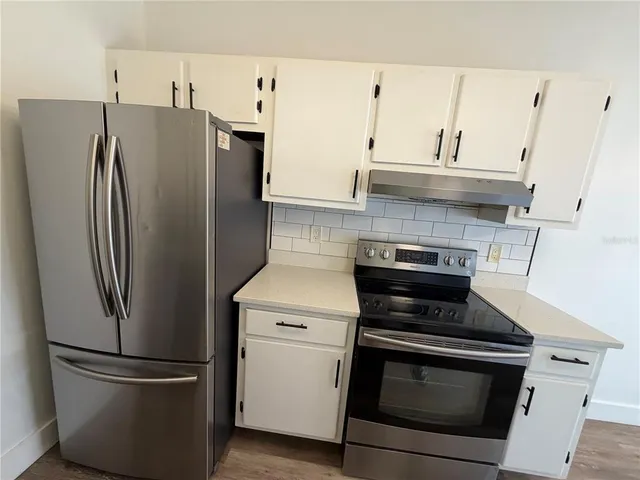 a kitchen with cabinets and stainless steel appliances