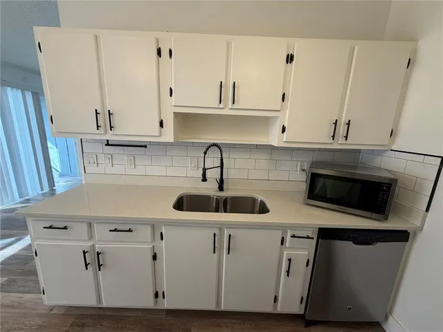 a kitchen with stainless steel appliances white cabinets and a sink