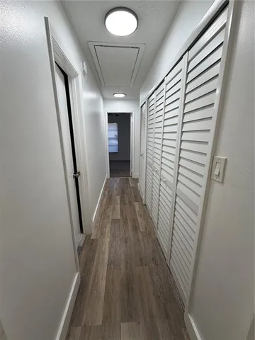 an empty room with a chandelier fan and closet area
